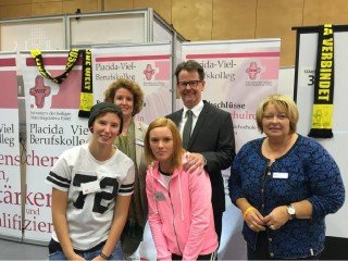 Besuch am Messestand: Mendens Bürgermeister Volker Fleige(Mitte) mit der stellvertretenden Schulleiterin Kerstin Kocura (r.), Schülerinnen und Studien- und Berufswahlkoordinatorin Beatrix Steinschulte. Foto: SMMP