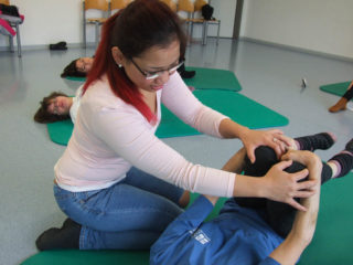 Die angehende Heilerziehungspflegerin Kwanhatai Chimpornpraphan gibt Hilfestellung bei der Yoga-Übung. Foto: SMMP/Hofbauer