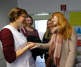 Wiedersehen in der Schulküche: Abiturientinnen von 2014 überraschten Lehrerin Dorothee Krause. Foto: SMMP/Hofbauer